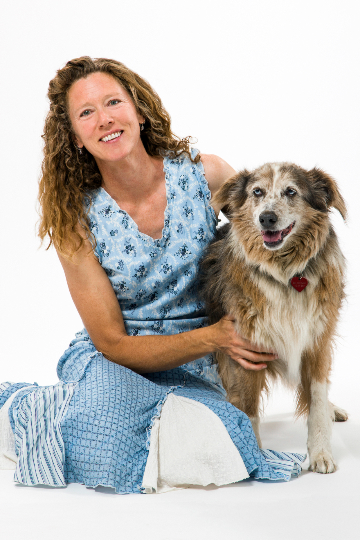 Studio photograph of attractive woman in summer dress with her pet dog, Miss Kitty, an Australian Shepherd mix