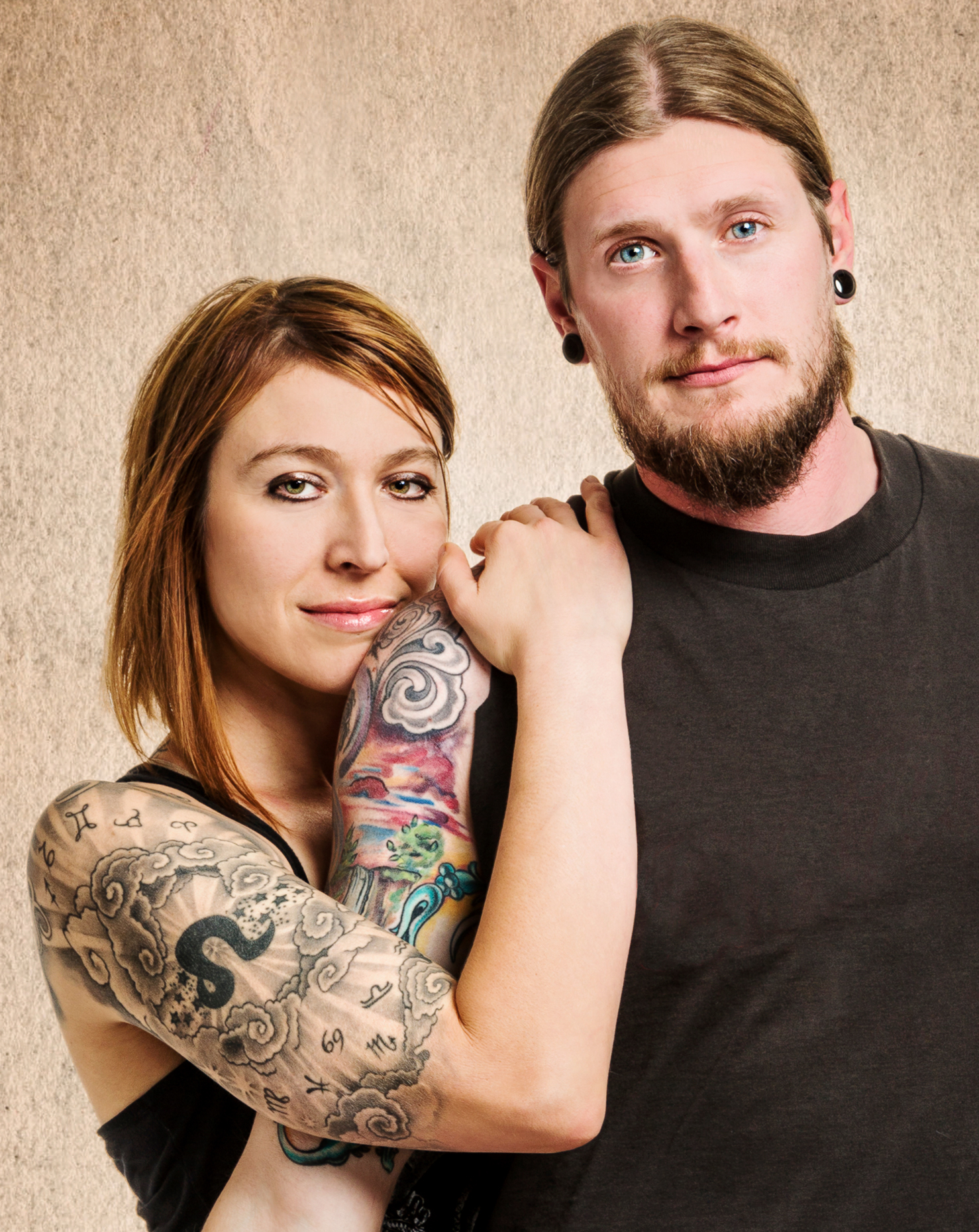 Studio portrait of man and woman with tattoos