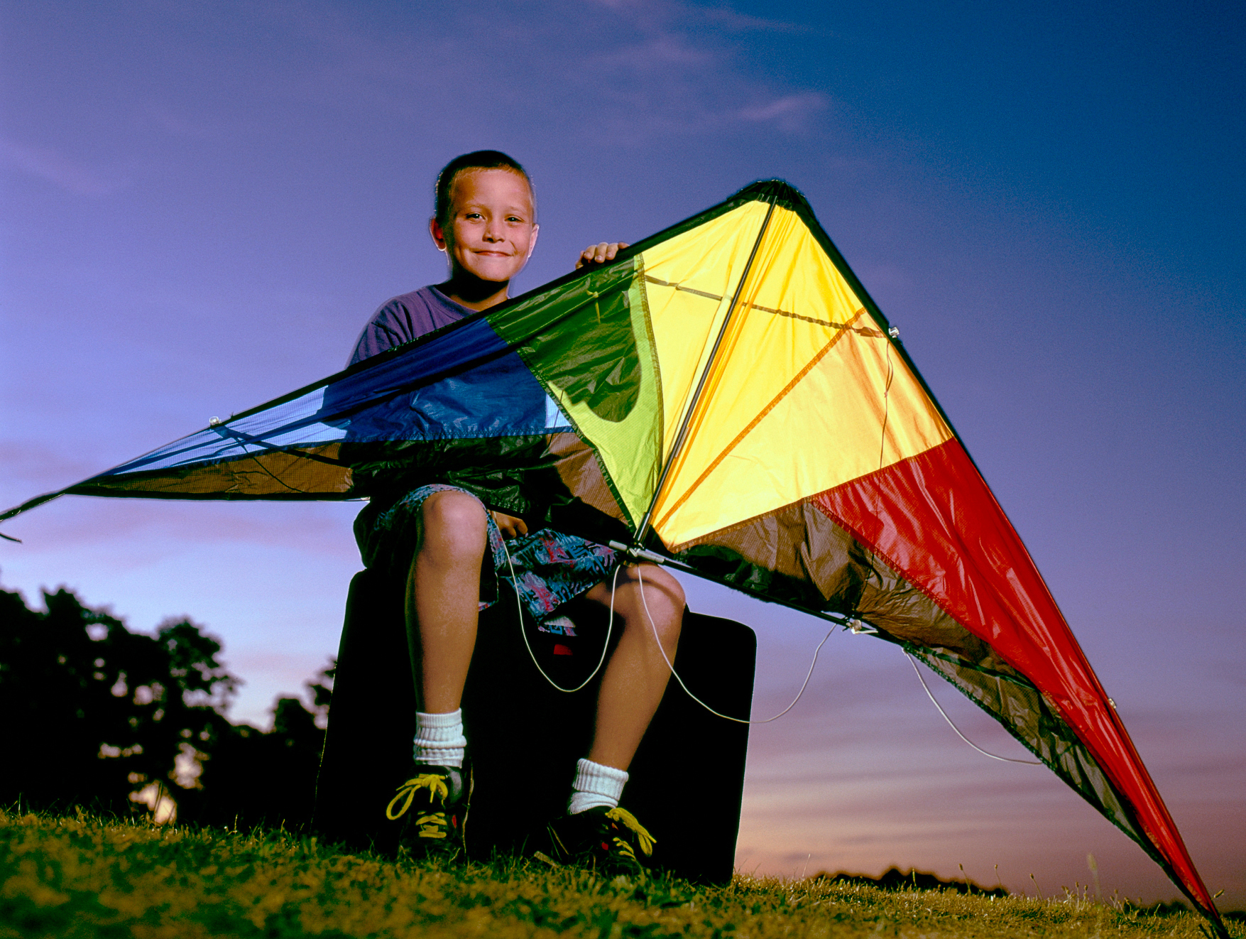 Dusk portrait of young male stunt kite flyer