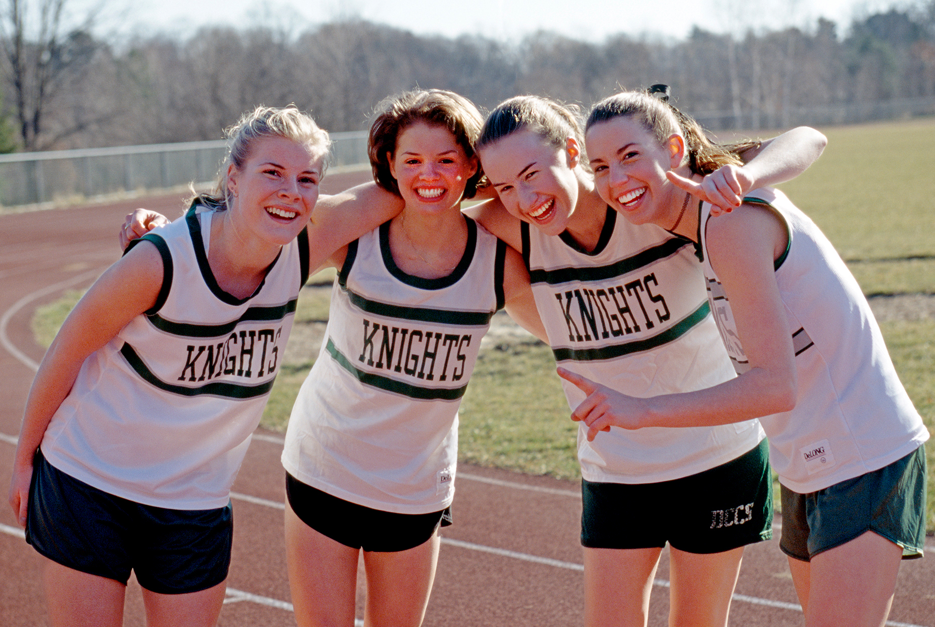 Teenage girls on a high school track team celebrate victory
