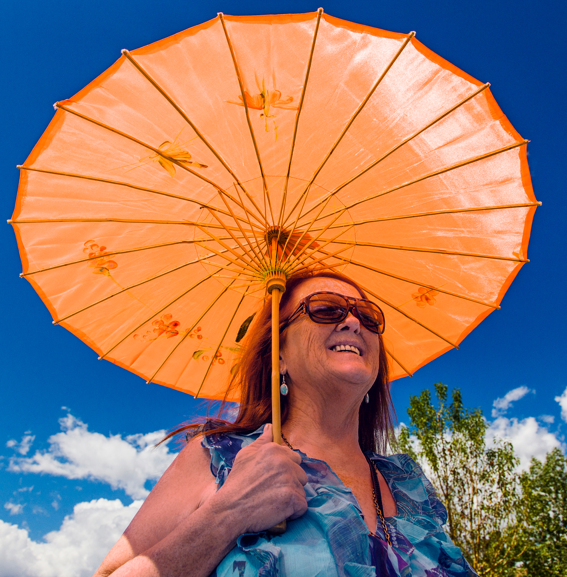 Outdoor portrait of woman with an orange parasol, small mountain town of Buena Vista, Colorado, USA