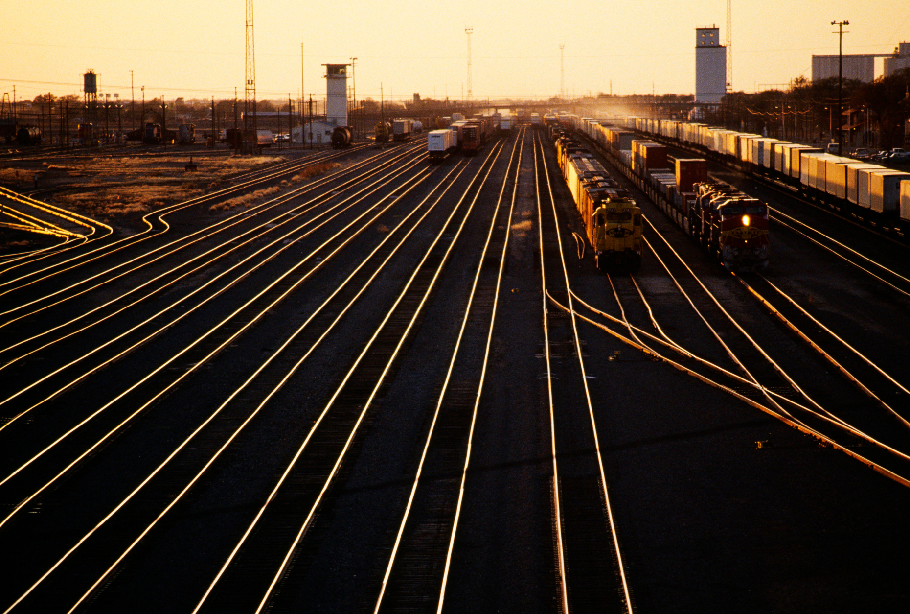 Setting sun reflecting off the rails in a train yard, Clovis, New Mexico, USA