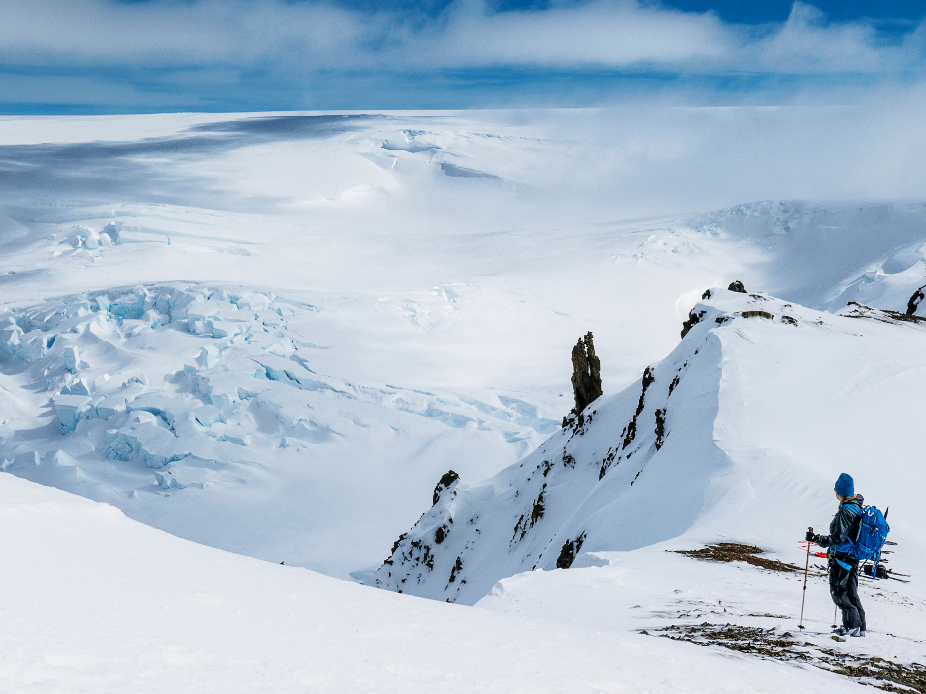 Ski mountaineers roped together for safety from crevasses use synthetic skins on skis to climb uphill; Antarctica