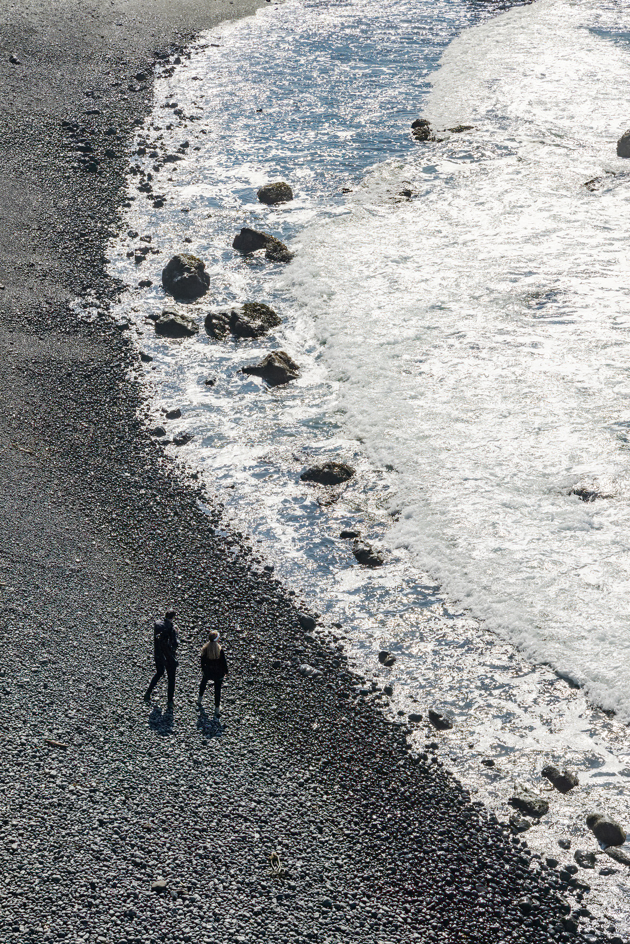 People walk on the rocky beach near the Yaquina Lighthouse; Pacific Ocean; Oregon coast;  Newport; Oregon