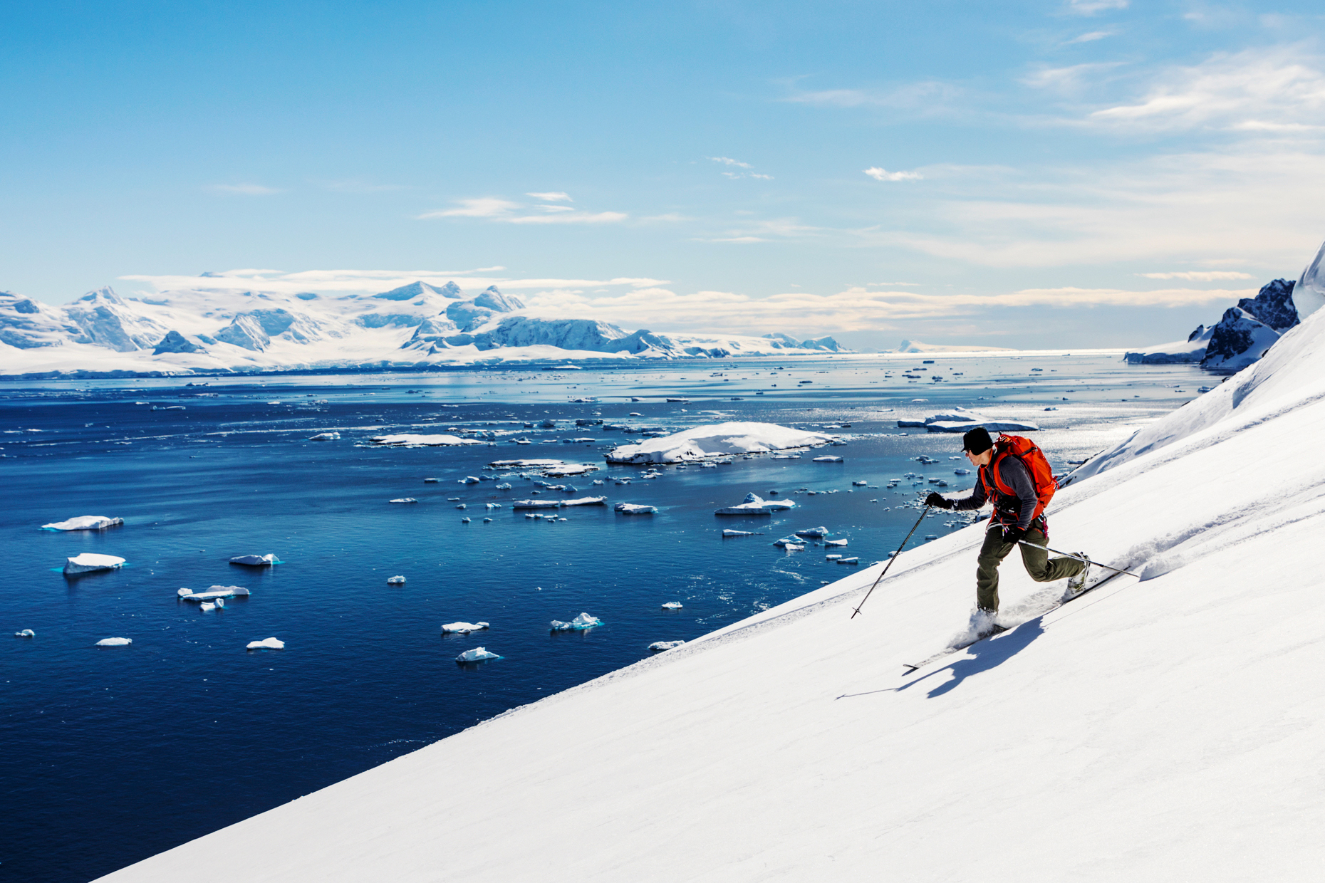 Alpine telemark ski mountaineer skiing downhill in Antarctica; Rongé Island; Arctowski Peninsula