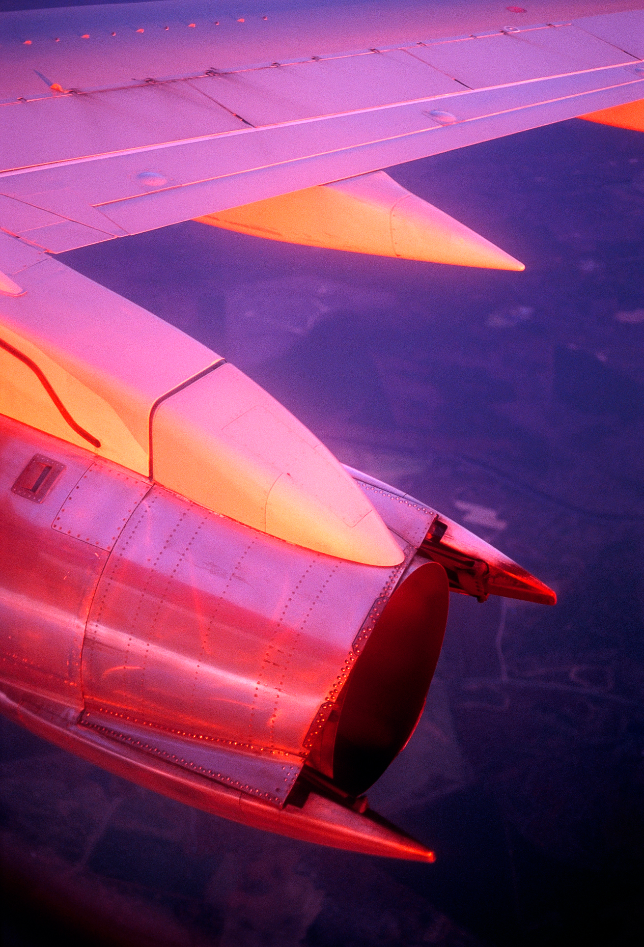 Setting sun illuminates the wing and jet engine of a commercial 