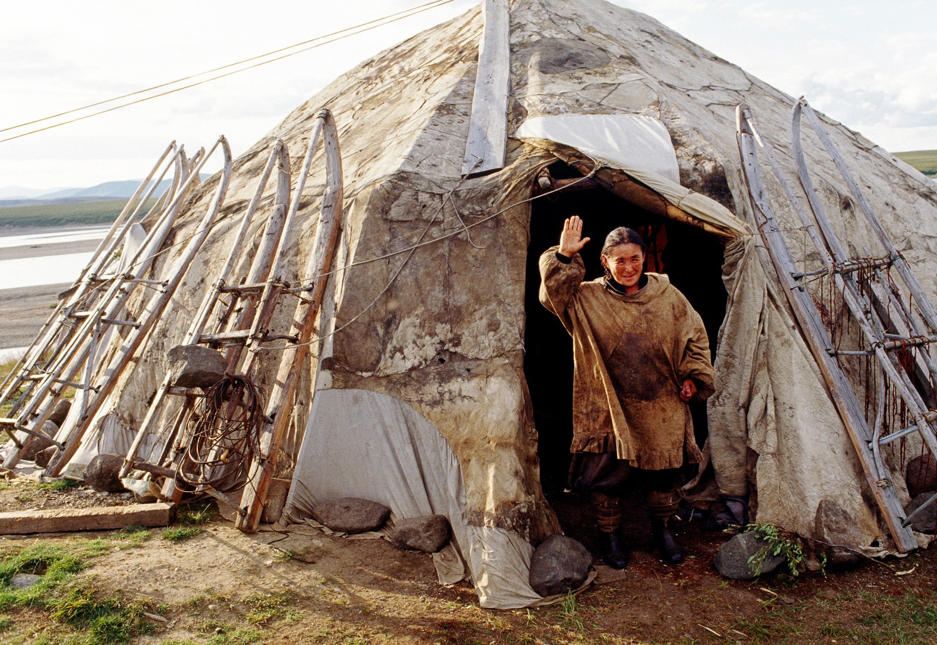 FEMALE CHUKCHI HERDER WAVES FROM THE DOOR OF HER YURT, AMGUEMA, MAGADAN REGION, CHUKOTKA, RUSSIAN FEDERATION; FORMER USSR SOVIET UNION