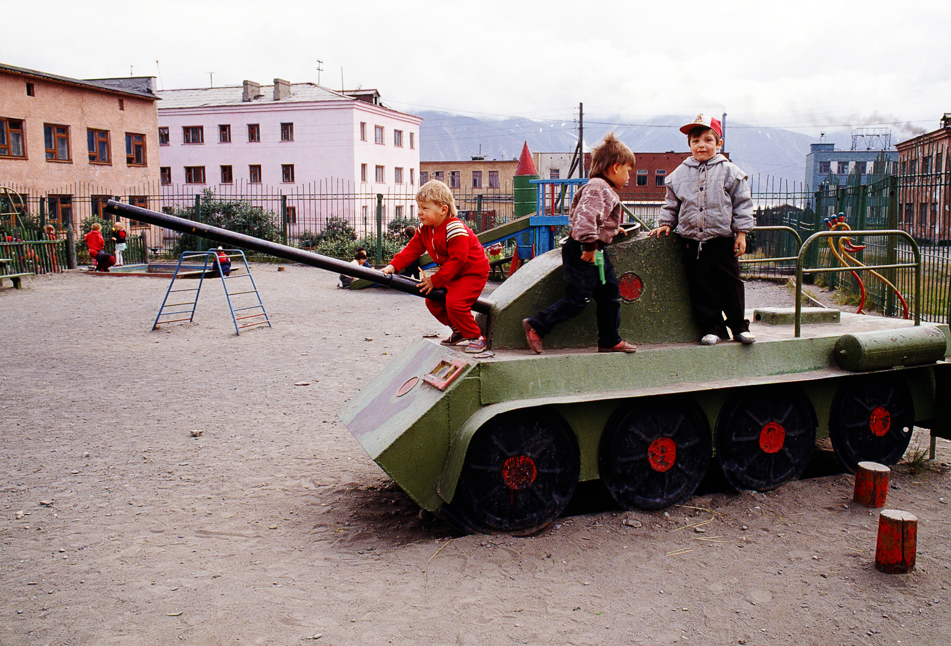 Soviet children playing on a toy tank in a school playground, Eg