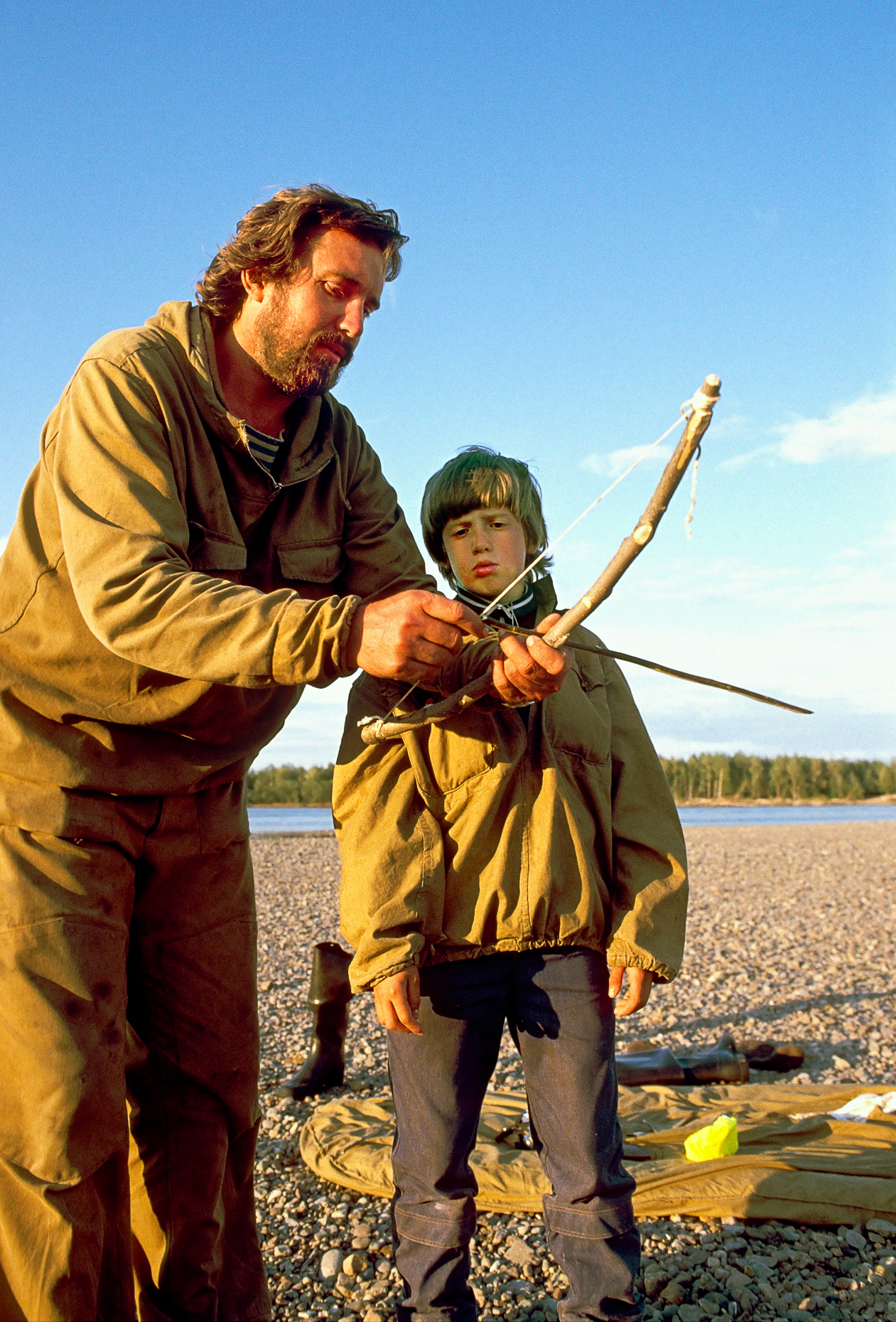 River guide teaching his son to shoot an arrow with a home made bow, Chukchi Peninsula, Magadon Region, Siberia, former Soviet Union