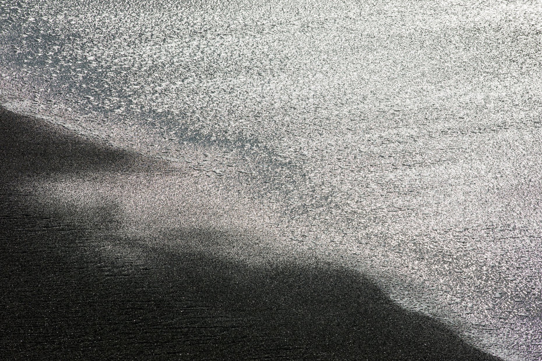 Close up abstract view of waves washing up on the beach at San Simeon State Park, San Simeon, California, USA