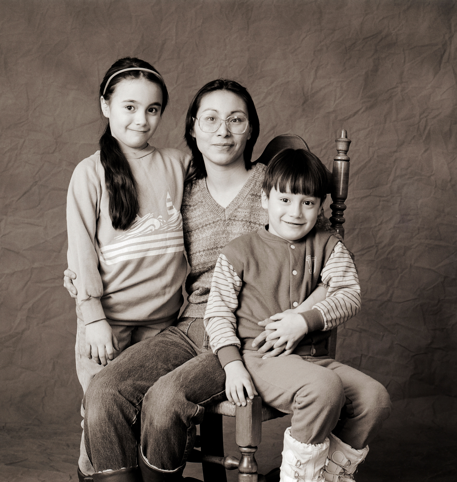 Black & white studio portrait of Inuit woman and her two children in a photography studio in Iqaluit, Nunavut, Canada