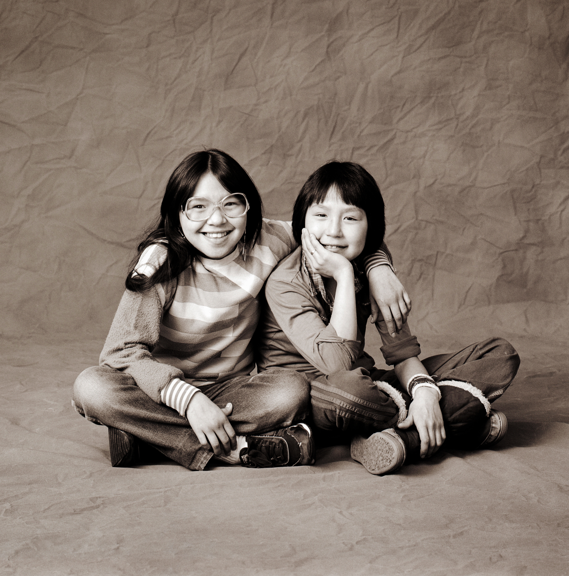 Black & white studio portrait of two Inuit girls in a photography studio in Iqaluit, Nunavut, Canada