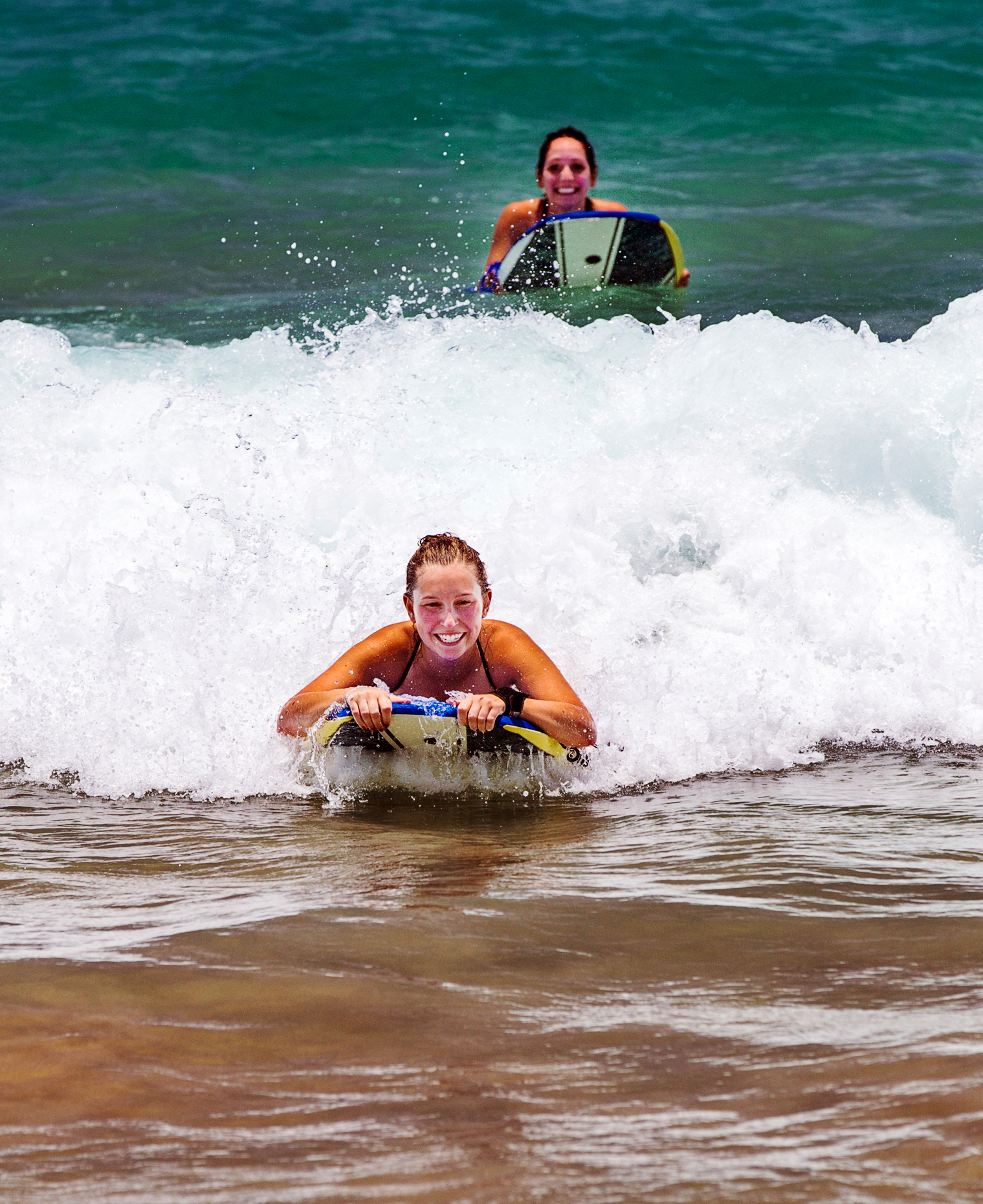 Girls surfing waves, Hapuna Beach, Kohala Coast, Hawai