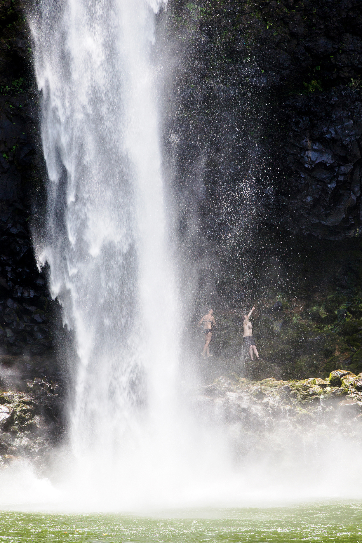 Couple hiking behind Wailua Falls, Kauai, Hawaii