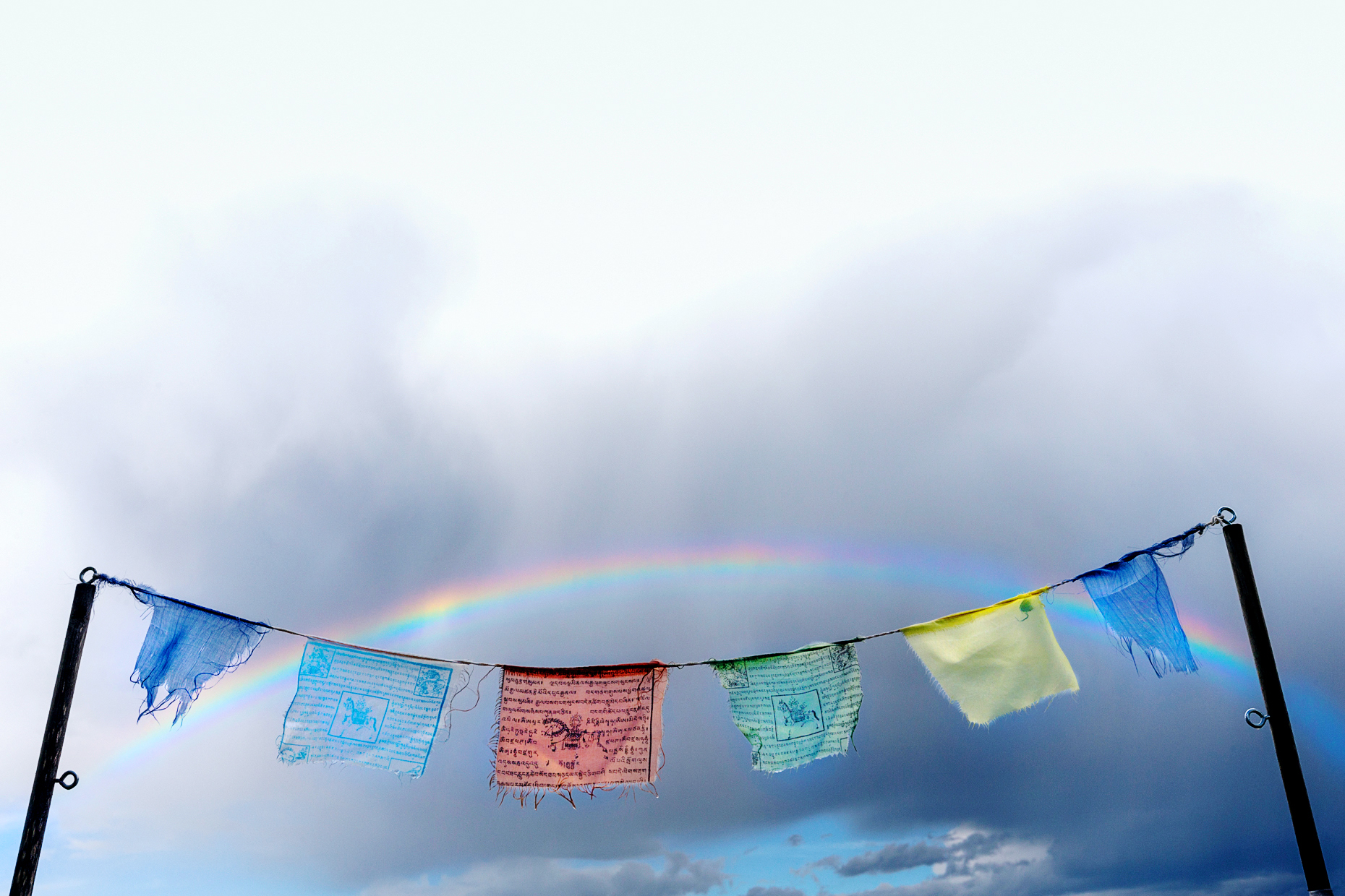 Rainbow over traditional Buddhist prayer flags; small mountain town of Salida; Colorado; USA