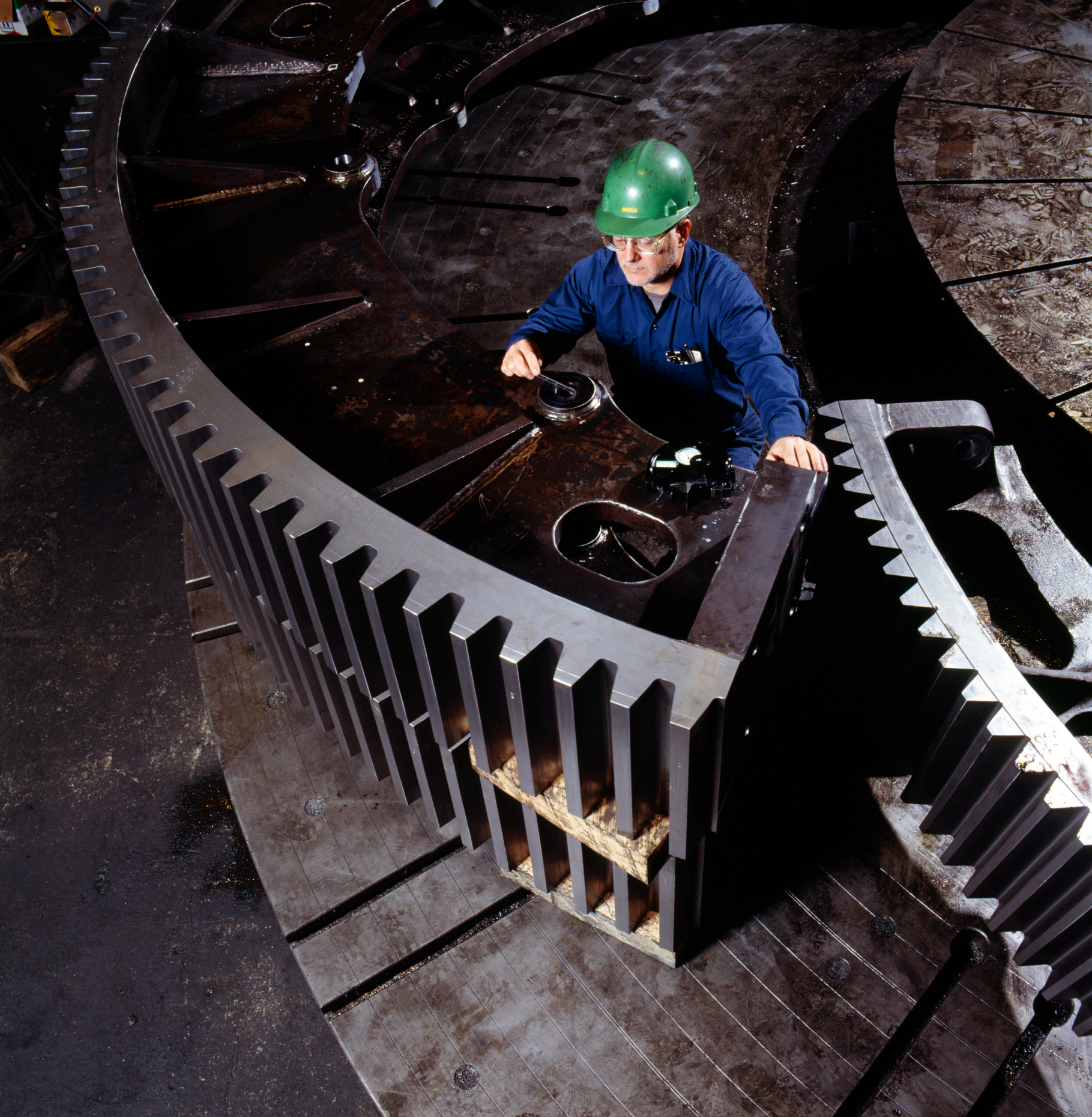 Metal worker checks quality control tolerances on the teeth of l