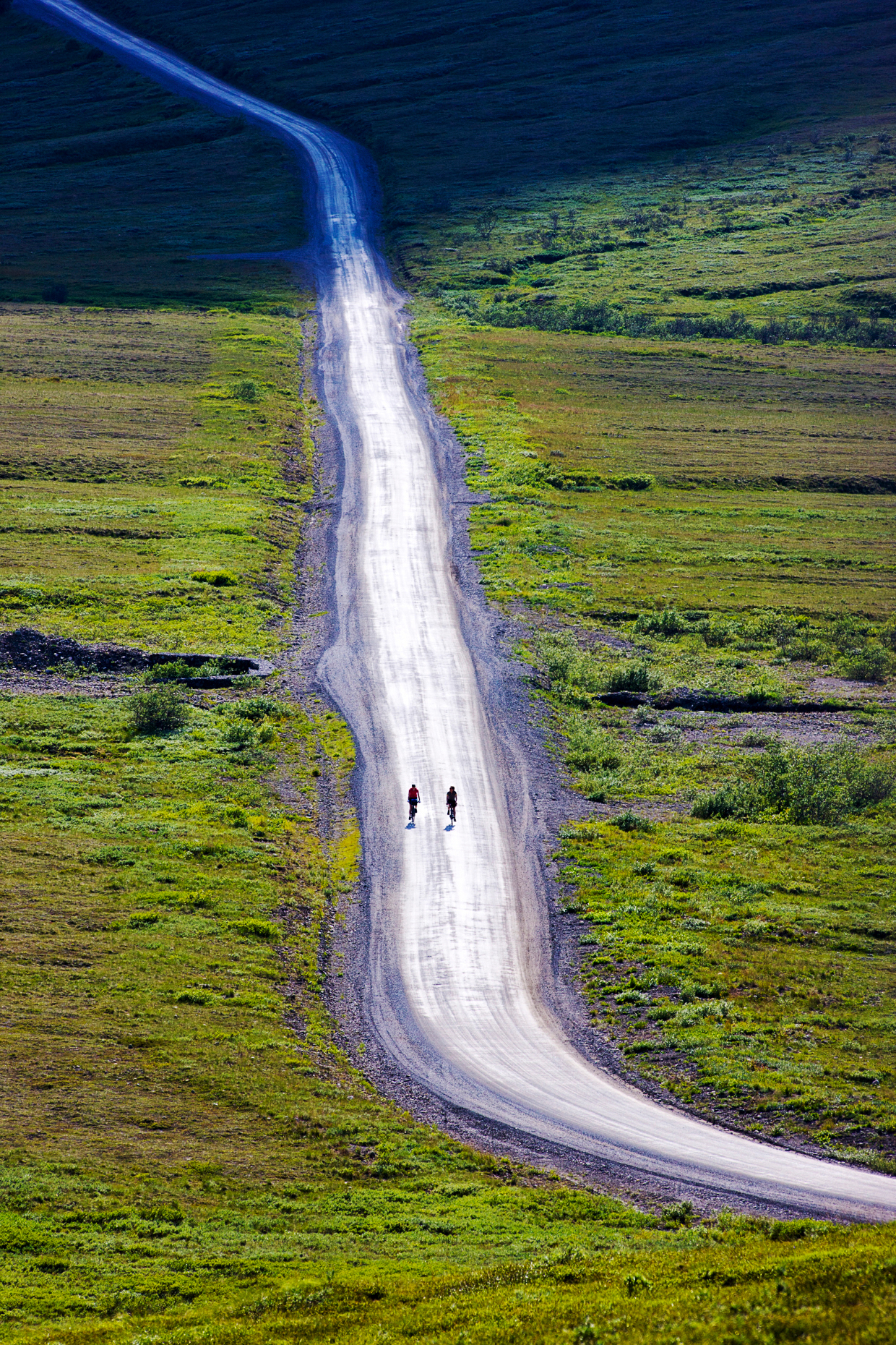 Two cyclists riding the limited access road towards Stony Dome, Denali National Park, Alaska, USA