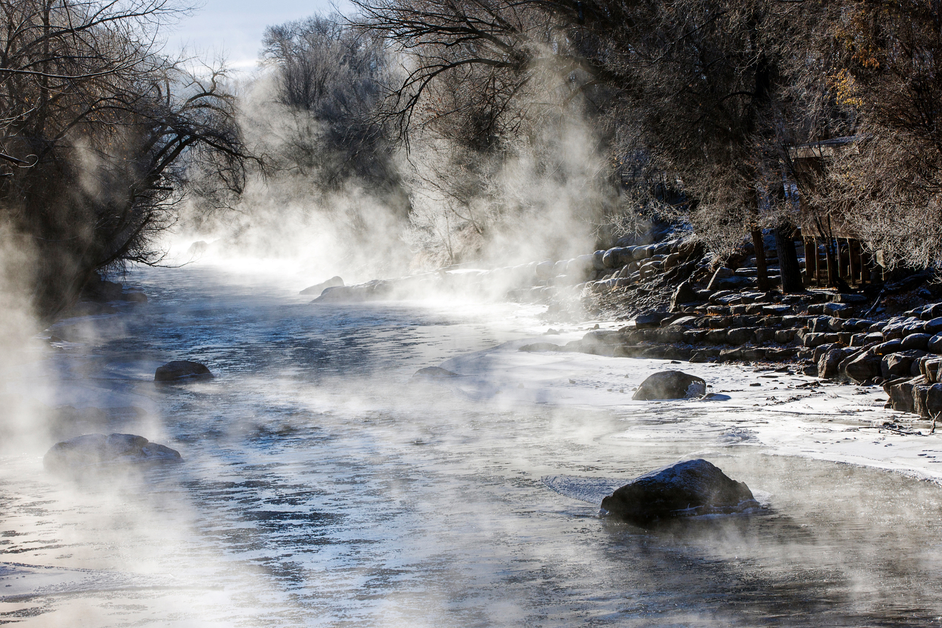 Steam rises on a sub-zero morning from the snow and ice choked Arkansas River, which runs through the downtown historic district of the small mountain town of Salida, Colorado, USA