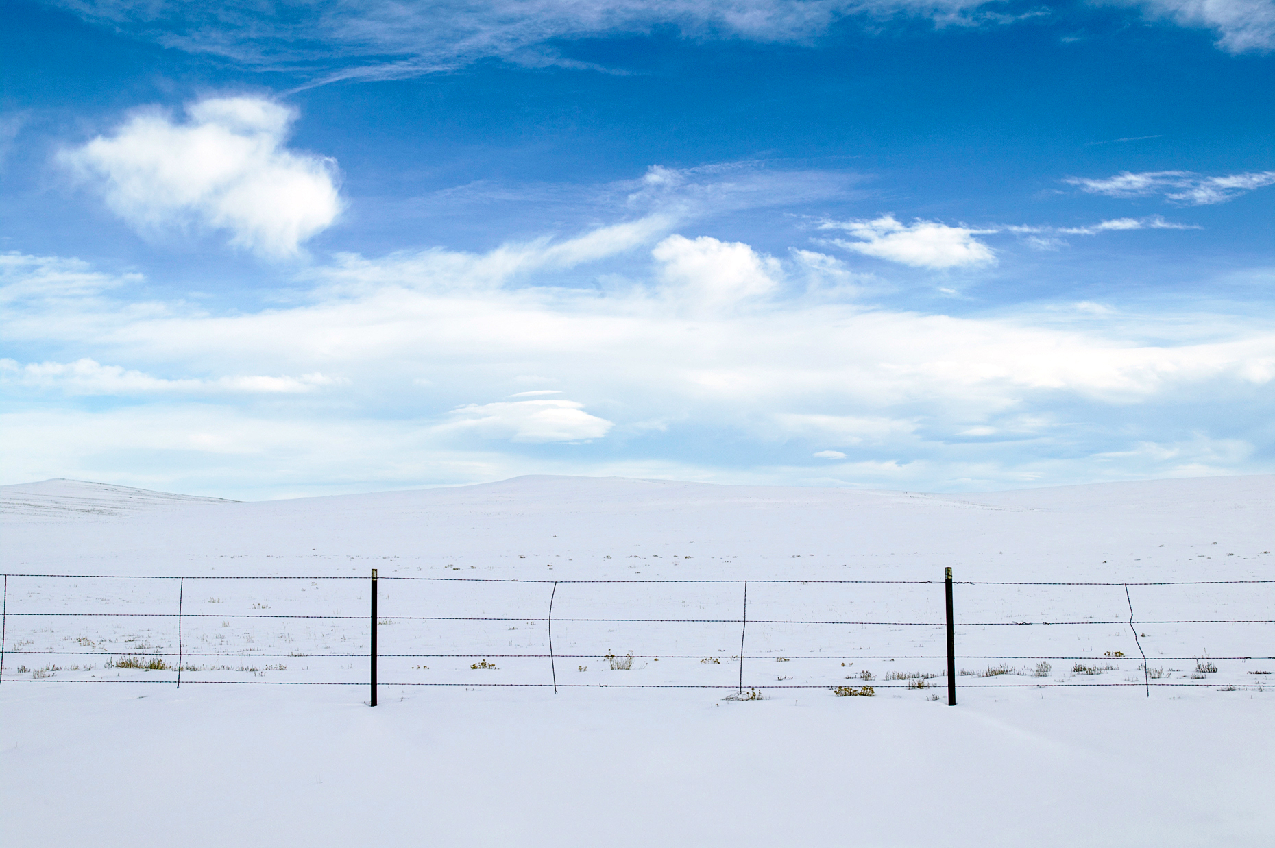 Clouds, snow & ranch fence near Fairplay, CO