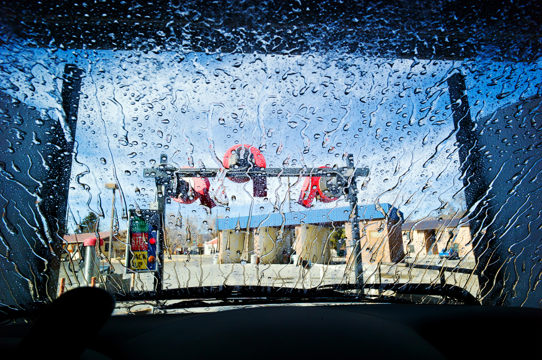 View through the windshield of an automobile in an automated car wash.