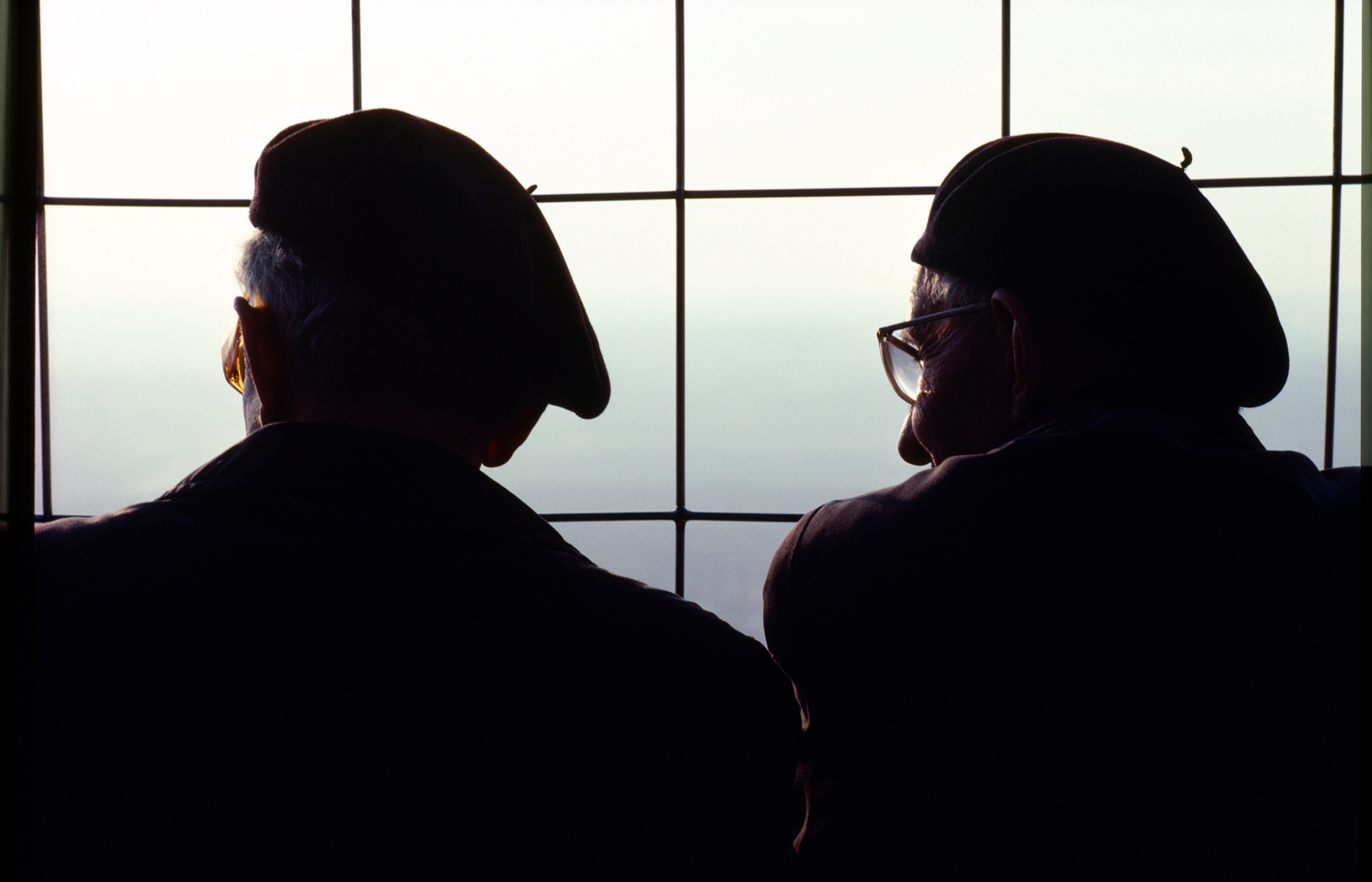 Two frenchman wearing berets share the view from the top of the 