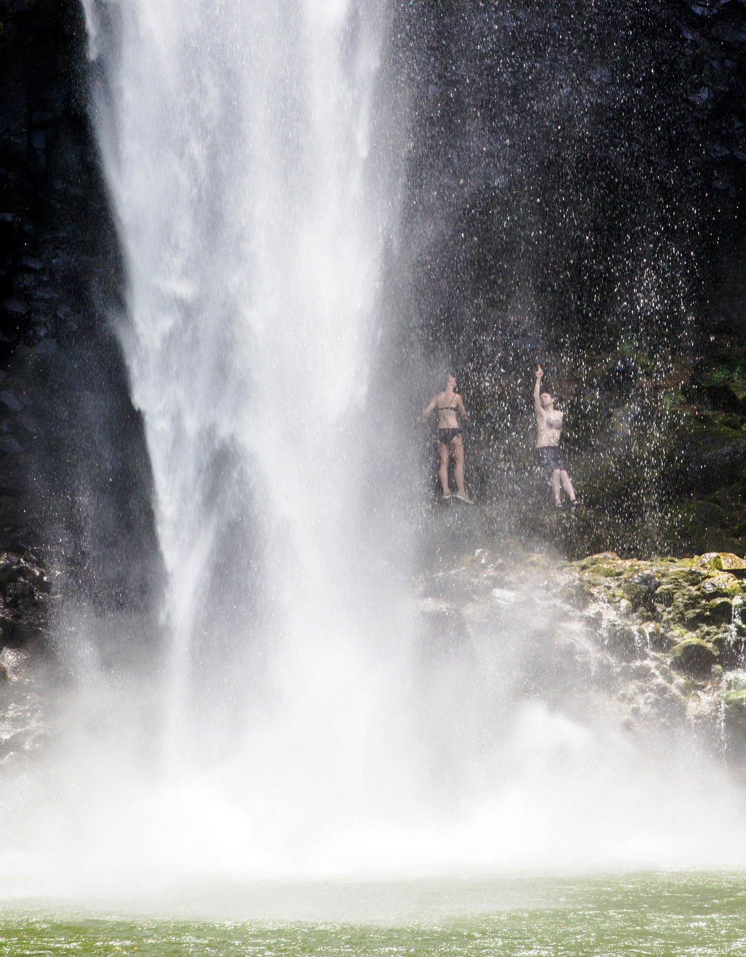 Couple hiking behind Wailua Falls, Kauai, Hawaii