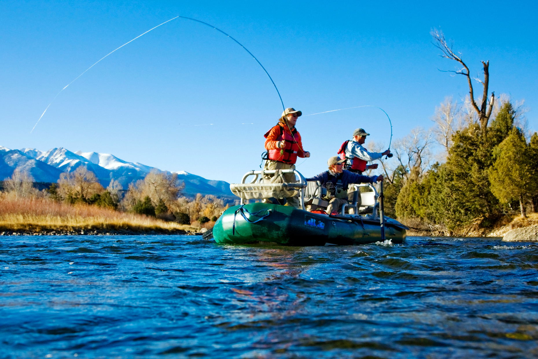 Married couple and professional guide fly fishing from a boat on the Arkansas River, near Salida, Colorado, USA